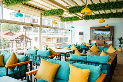 cafe terrace with turquoise sofas and yellow pillows
