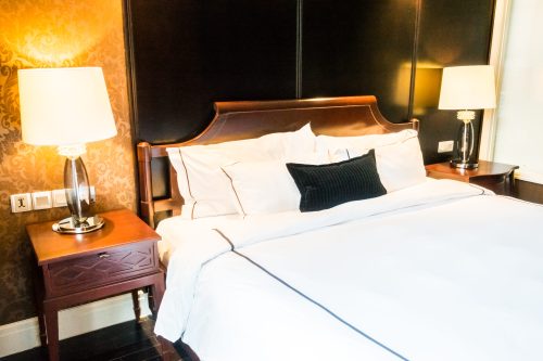 White pillow on bed with table light lamp decoration in bedroom interior